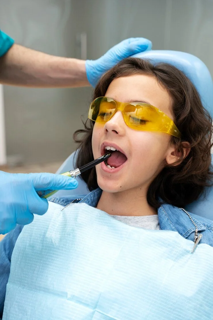 Child patient with cleaning instrument in mouth